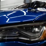 Process of applying ceramic protective coat on body car using sponge in detailing auto service. Car service worker apply ceramic coating to protect the car body from scratches